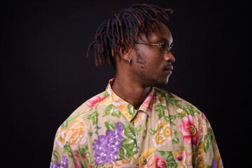 Young African man with dreadlocks against black background