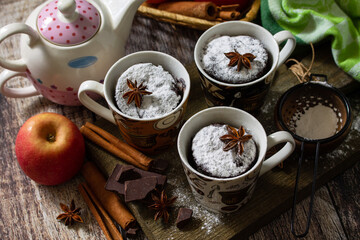 Autumn apple pie mugcake with red apples and spices on a rustic background.