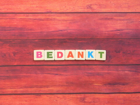 Dutch word Bedankt meaning Thanks on wood background