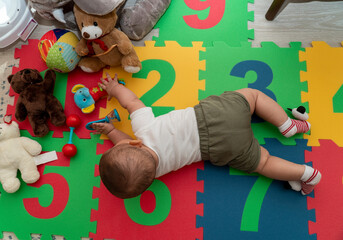 Child playing with colorful toys. Baby room.