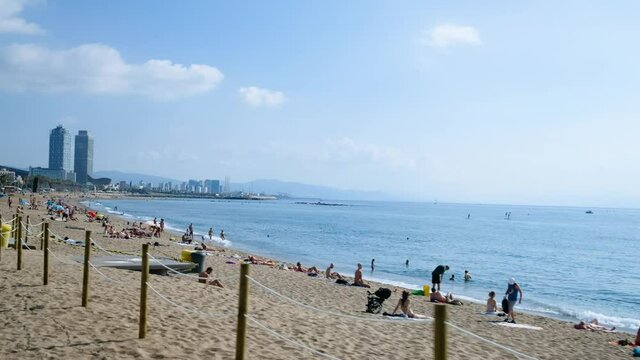 Barcelona, spain - 20 july july 2020: view of barceloneta beach on a sunny summer day, symbol tourism and travel industry crisis after corona virus travel restrictions, holidaymakers at the beach