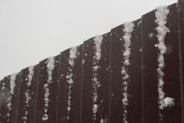 Snow covered fence. Metal fencing.