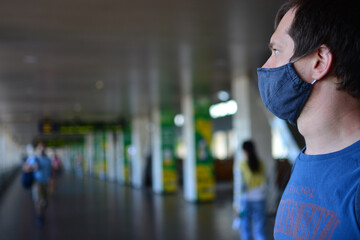 Coronavirus outbreak in Kyiv, the capital of Ukraine: passengers walk along the Central Railway Station in protective face masks. Man in black face mask.