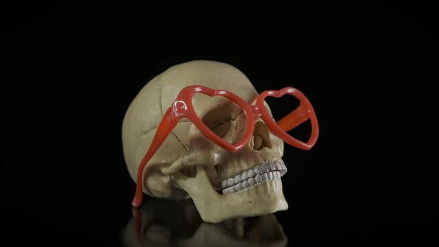 Skeleton in glasses. Human skull with glasses hearts.
