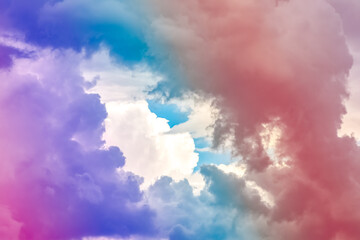 Fluffy white clouds in a bright blue sky.  Dramatic and colorful cloud background with mixed pastels.