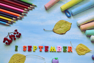 Back to school composition with color pencils, chalks and  1 September text against light blue...