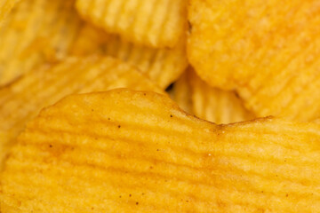 Corrugated potato chips, the texture of the surface. Close up.
