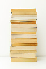 Stack of paperback books against white background with only the pages showing.