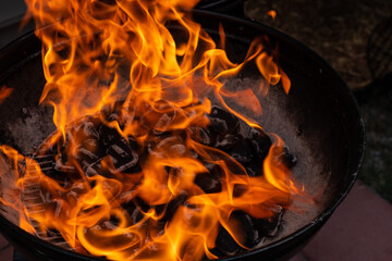 Close-up of a blazing fire in rustic BBQ grill at the evening.