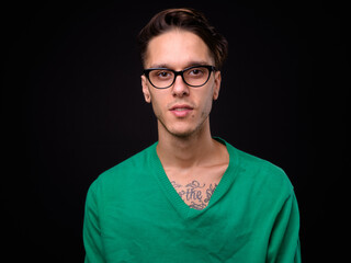 Young handsome rebellious man against black background