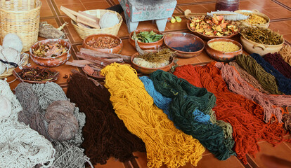 Natural sheep wool, dyed with natural dyes . Wool lies on the tile floor next to the clay bowls are natural materials from which dyes are obtained.