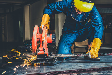 Professional mechanic is cutting steel metal with rotating diamond blade cutter. Steel industry and...
