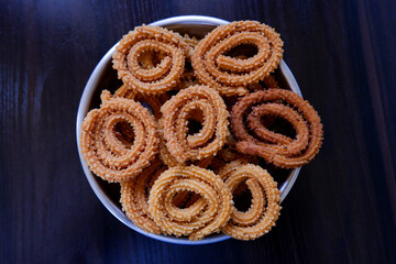 top shot of cultural homemade murukoo snacks in plate on dark wooden table