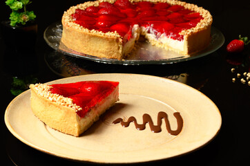  slice of strawberry pie with ground cashew nuts on a dark glass table