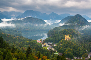 Fototapeta na wymiar Hohenschwangau, Germany landscape with the castle and Lake Alspee with a rolling fog.