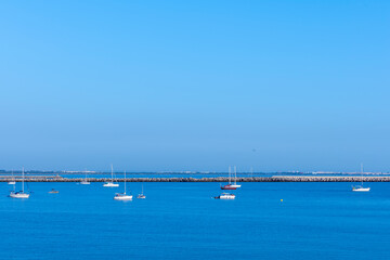 Fototapeta na wymiar Embarcaciones de recreo en la playa de La Puntilla, ubicada en el municipio de El Puerto de Santa María, provincia de Cádiz, España