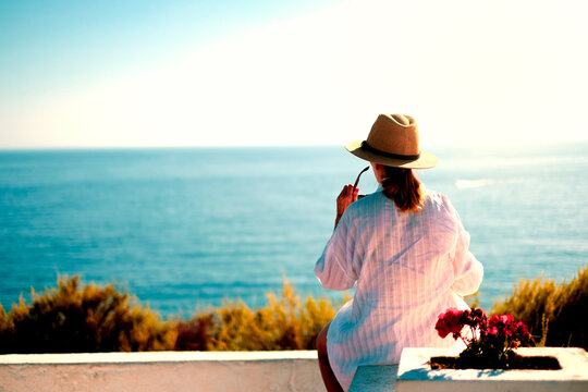 donna in camicia di spalle che osserva l'oceano sul mare in vacanza