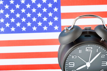 Close up of retro analog clock on USA american flag background.