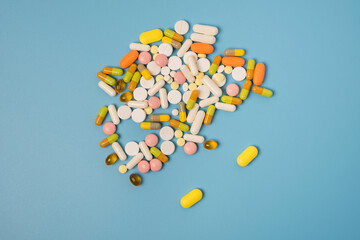 Close up of many different pills on blue background.