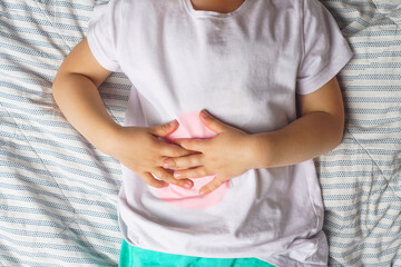 abdominal pain in a preschool child. poisoning in children. the boy holds his hands to the abdominal cavity