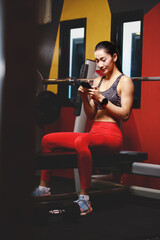 Fototapeta premium asian woman using smartphone in gym
