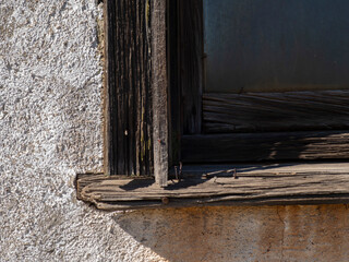 A weathered window frame on a rustic old building