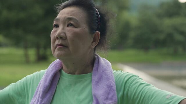 Asian Elder Woman Rotating Her Body To Warm Up Before Workout At The Public Park, Turning Body Hips Arms Full Stretch, Self-care Motivation After Retirement Life, Health Care, Aged Wrinkle Skin Care