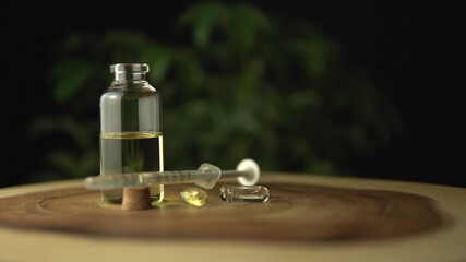 Obraz na płótnie Canvas Licensed cannabis CBD oil for medical purposes. Background with small glass jars and syringe, for oral use only. Hydroponic biological seeds and marijuana plant on wood table.