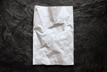 White crumpled paper on isolated black background. Paper mockup for design. Creased blank paper on black backdrop.