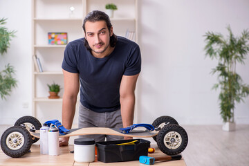 Fototapeta na wymiar Young male repairman repairing skateboard