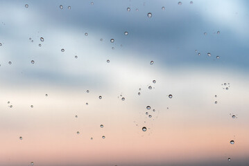 round drops of water on glass on blue and red background