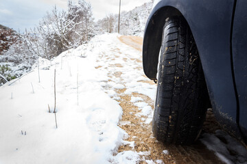 Wheel of a car on snow. Winter tire on sowy road. Automobile in winter concept. © hasbisahin