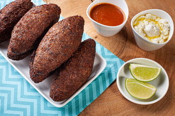 .Kibe Fried. Very typical in Brazil. Accompanied by lemon, curd, orange juice and pepper sauce. Top view