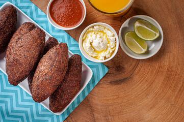 .Kibe Fried. Very typical in Brazil. Accompanied by lemon, curd, orange juice and pepper sauce. Top view