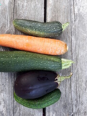 Cucumber, zucchini and eggplant on a wooden table. Vegetables, vegetarian food.