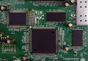 Close-up of electronic circuit board PCB with components: microchip, processor, integrated circuits, capacitors, resistances and electronic connections are noted. High-quality macro