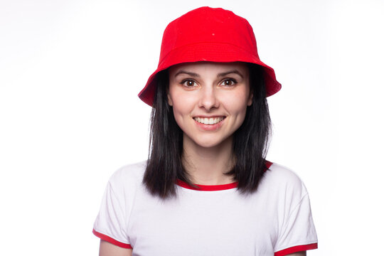 emotional woman in red panama and white and red t-shirt, light studio background