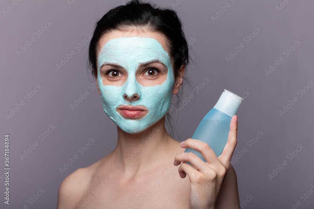 Wall mural spa girl applying face mask. cosmetic procedures.