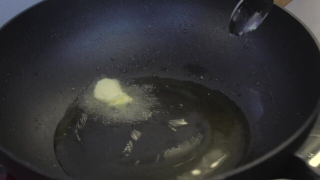 Poniendo mantequilla en sart&eacute;n caliente para cocinar