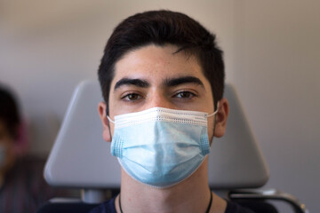A teenager on a train during covid-19.