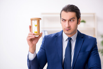 Young male employee in time management concept