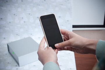female hands with phone close-up on the background of the box