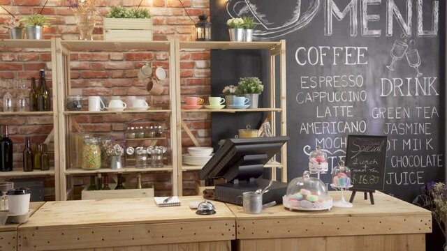 Empty cafe store interior in daytime. vintage style of coffee shop with wooden bar counter table and red brick wall in background. nobody in morning coffeehouse with menu writing on blackboard.