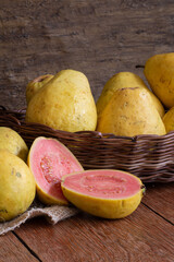Photo of guava fruit cut in basket on wooden background