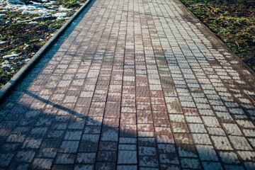 Nested pavers of various colors, around the grass is green, chic garden