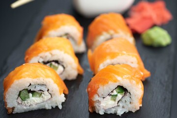 Sushi roll with salmon and lie on a black board made of slate stone