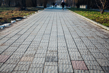 Nested pavers of various colors, around the grass is green, chic garden