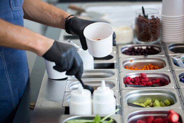 Stir-fried ice cream rolls at freeze pan. Rolled ice cream, hand made ice cream dessert. Fried ice cream machine with steel chilled pan.