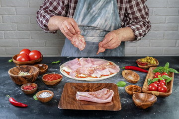 Pizza preparation with chef hands. Pizza making process decorating pizza