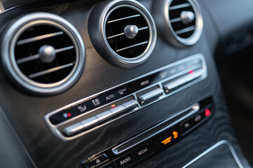 The center panel of the car interior with a view of the radio, air conditioning and other switches that make driving an elegant car more enjoyable.